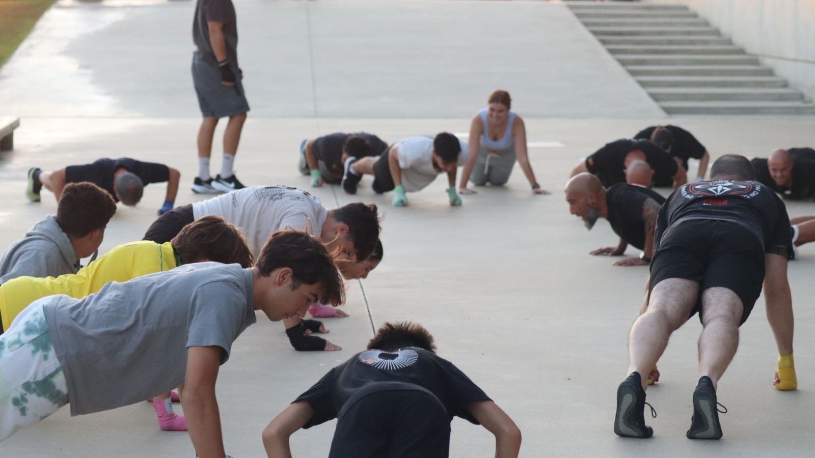 Grupo a fazer flexões em conjunto durante um treino ao ar livre